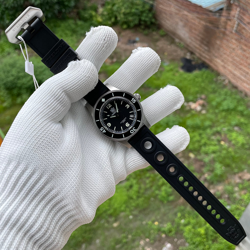 Steeldive SD1952 watch with black perforated rubber strap laid flat showing buckle and holes, with date