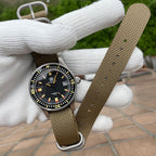 Steeldive SD1952T 300M on khaki single-pass nylon strap, lifestyle hand-held view