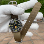 Steeldive SD1952T watch on khaki NATO strap held in gloved hand outdoors