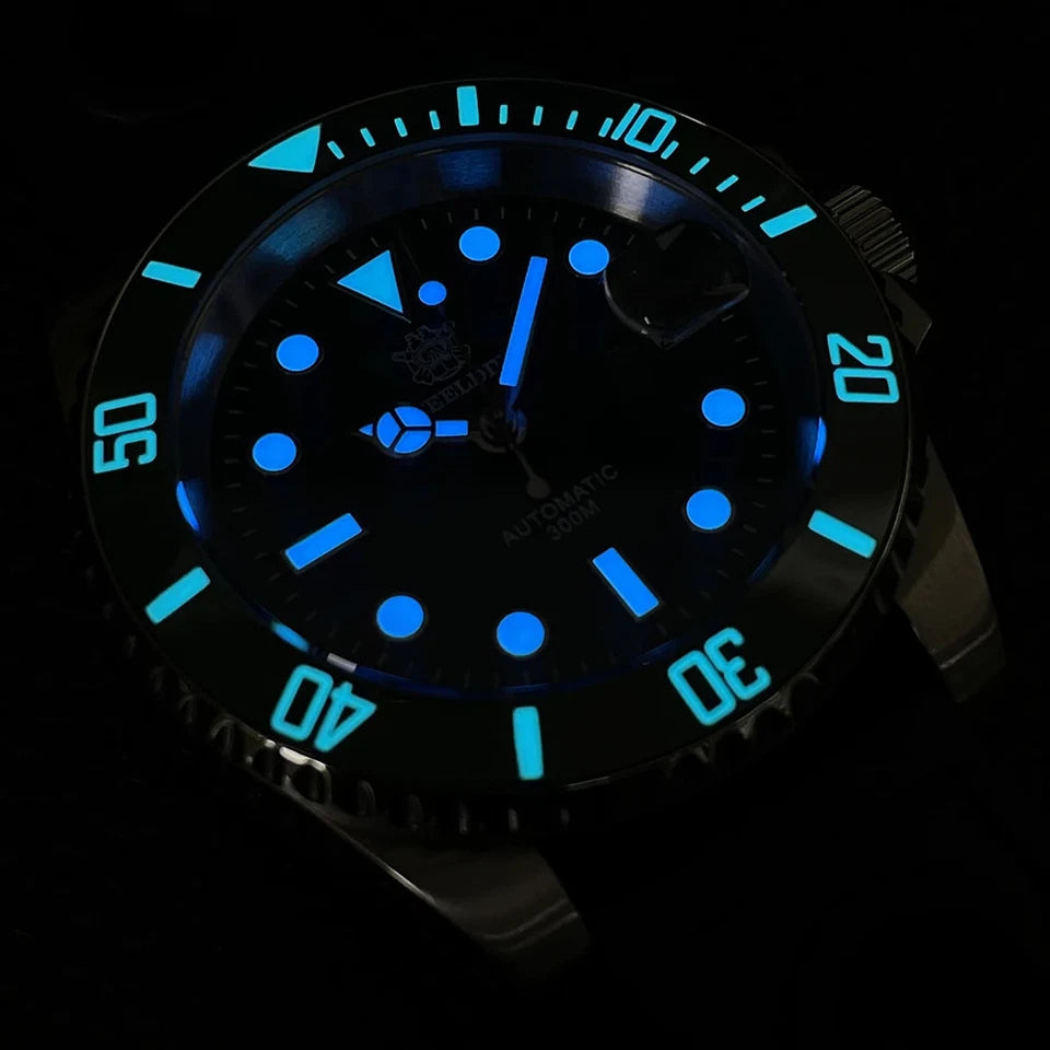 Steeldive SD1953 automatic diver watch with blue luminous dial and markers glowing in the dark, black bezel with blue luminous numerals, black dial, luminous markers and hands.