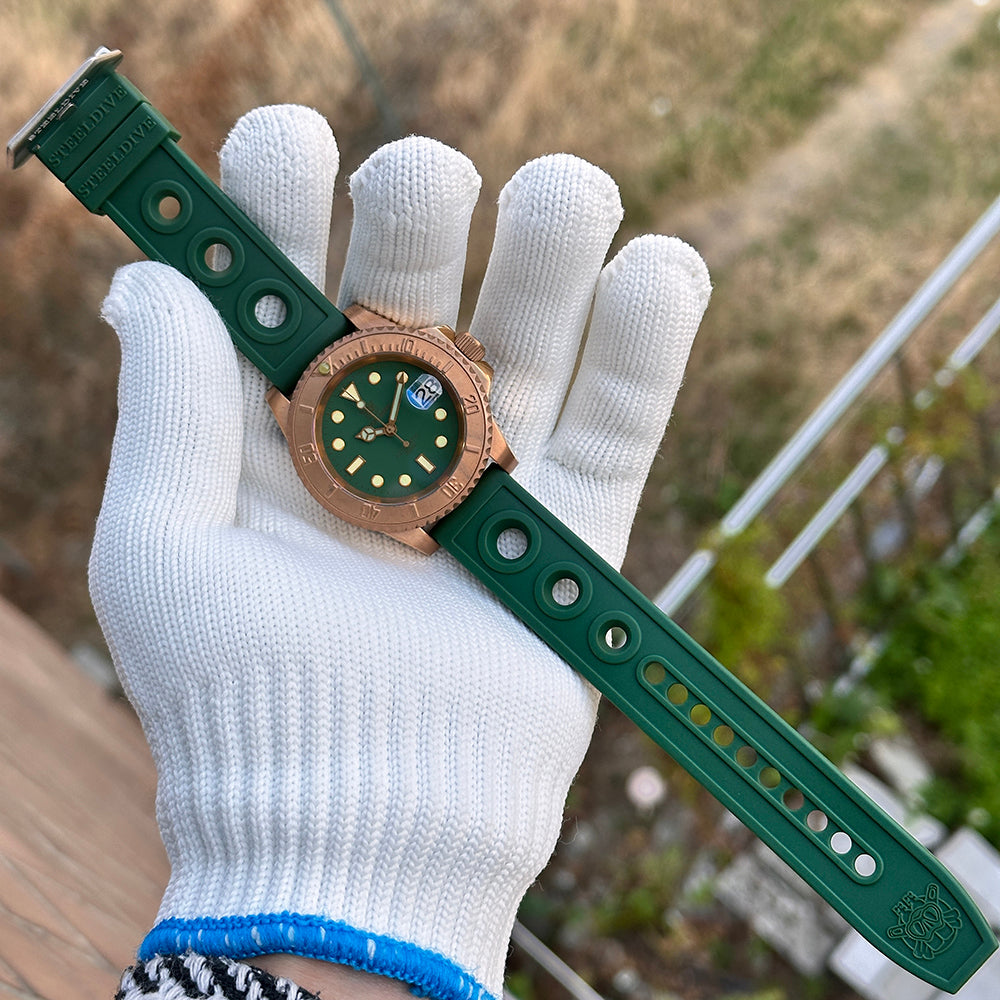 Steeldive SD1953S green dial bronze dive watch with monochrome bezel and green rubber strap held on hand