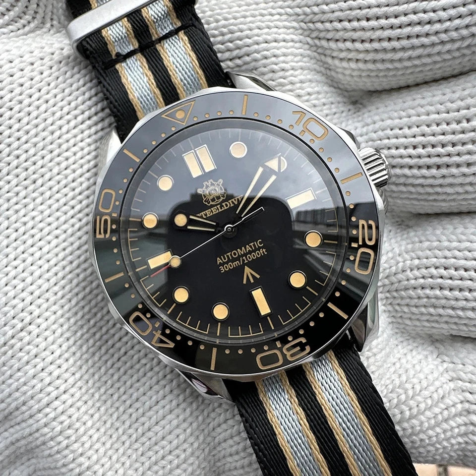 Steeldive SD1957 automatic watch with black dial, vintage bezel and striped black and gold nylon strap, resting on white gloved fabric background.