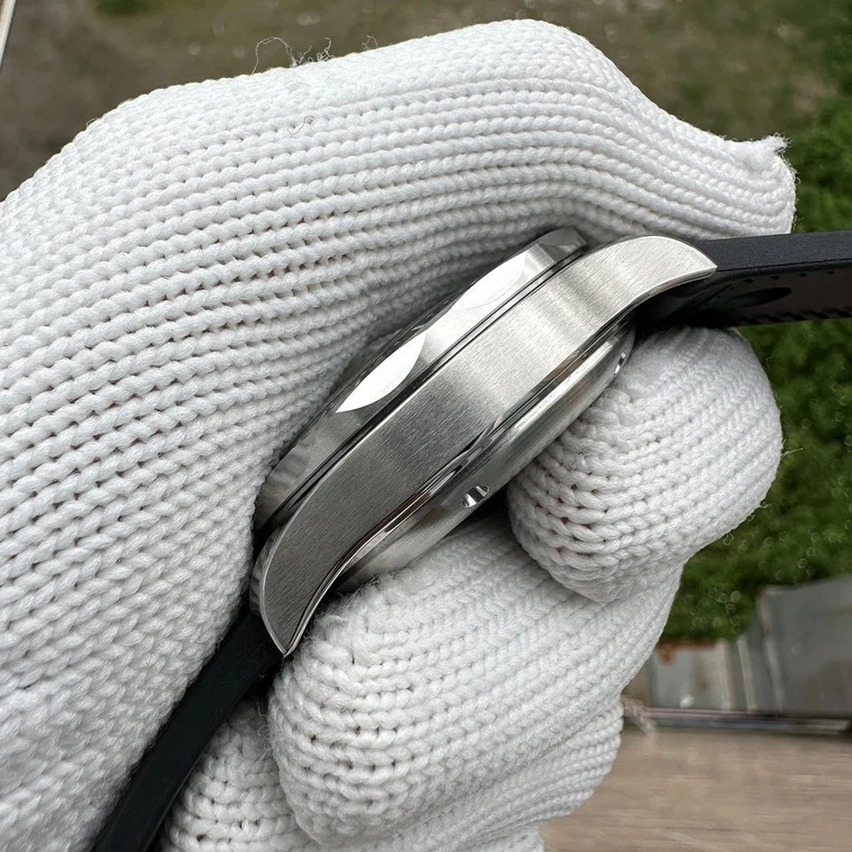 Close-up side view of Steeldive SD1957 watch showing polished stainless steel bezel and case with black strap, held by white gloved hand against a blurred outdoor background.