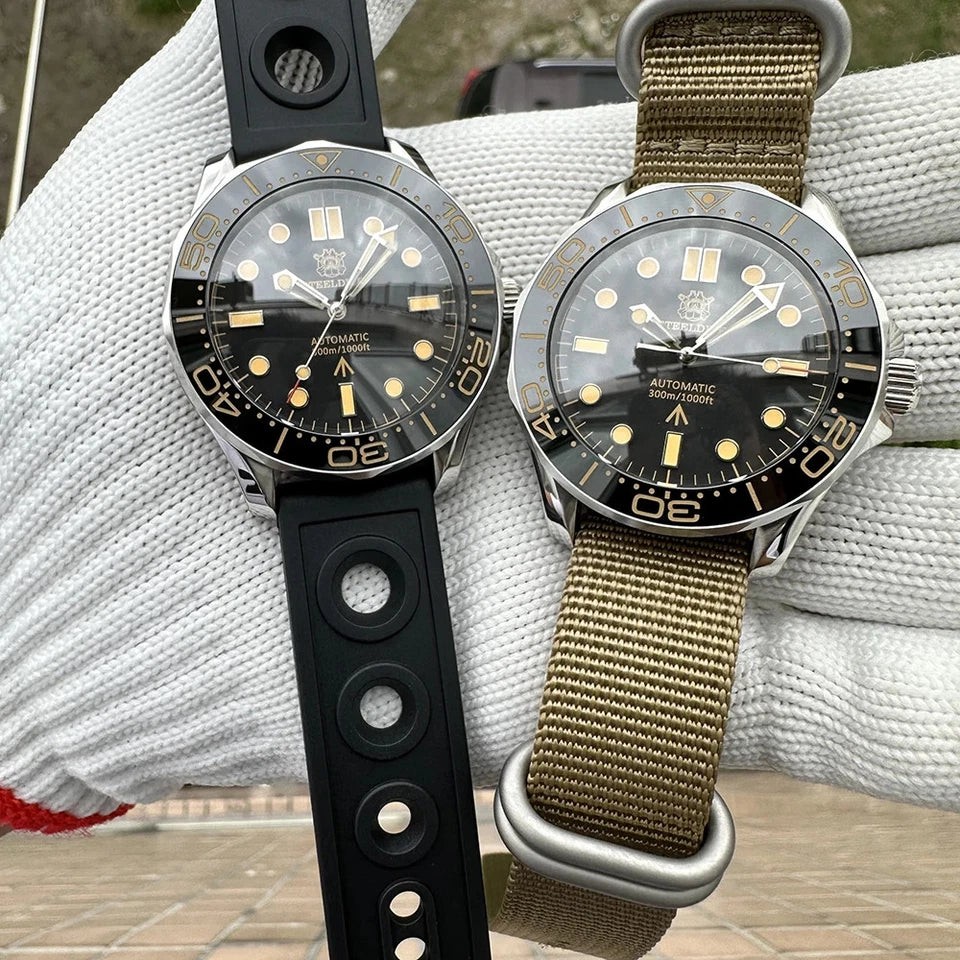 Side-by-side view of two Steeldive SD1957 automatic diver watches with black dials and vintage bezels, one with black rubber strap and one with khaki nylon strap, resting on a textured surface.