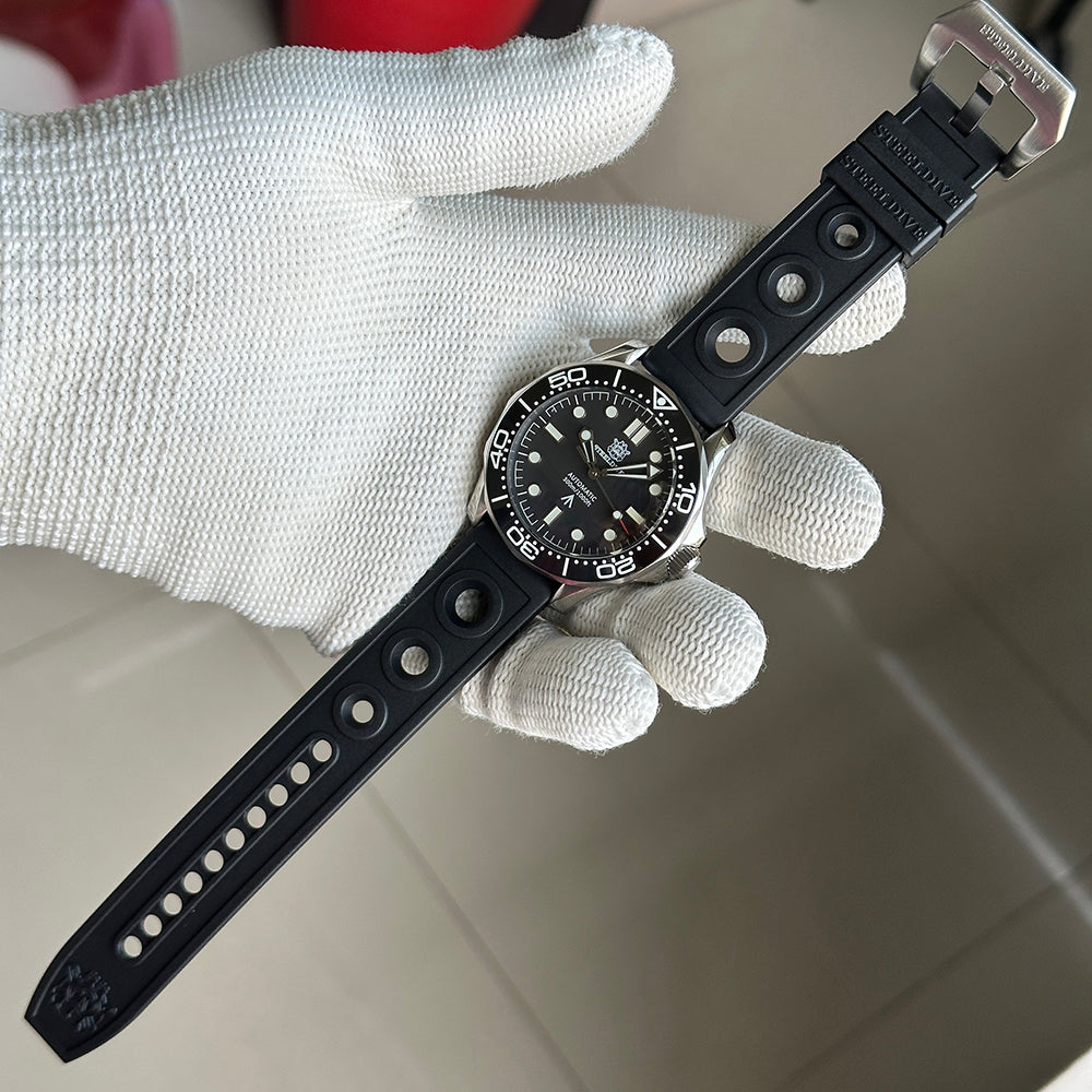 STEELDIVE SD1957L on a black perforated rubber strap held in a gloved hand