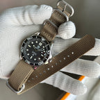 STEELDIVE SD1957L on a khaki nylon strap held in a gloved hand