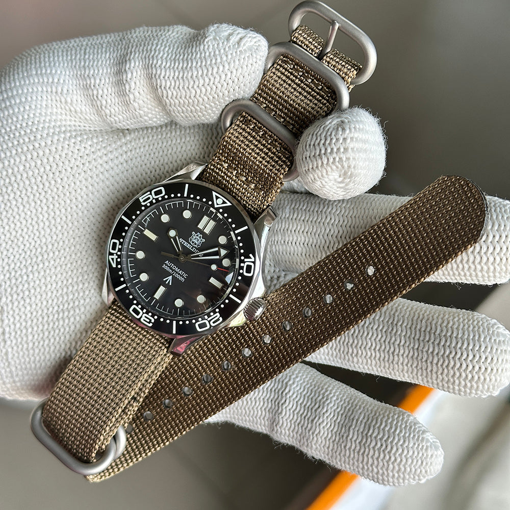 STEELDIVE SD1957L on a khaki nylon strap held in a gloved hand