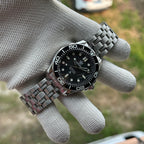 STEELDIVE SD1957L on a stainless steel bracelet held in a gloved hand