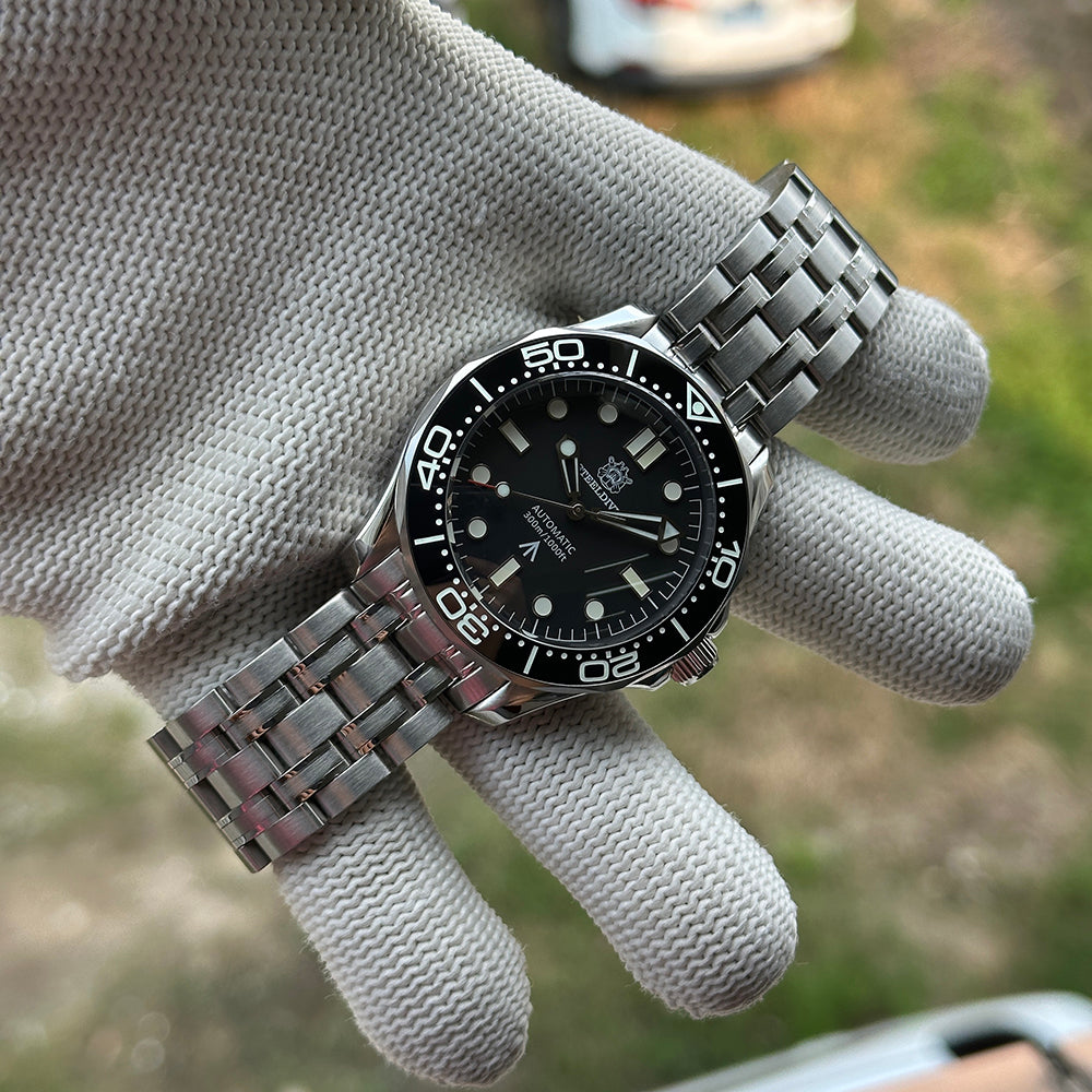 STEELDIVE SD1957L on a stainless steel bracelet held in a gloved hand
