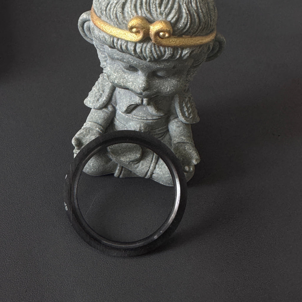 Steeldive SD1961 black ceramic bezel insert shown edge-on against figurine to highlight ring thickness