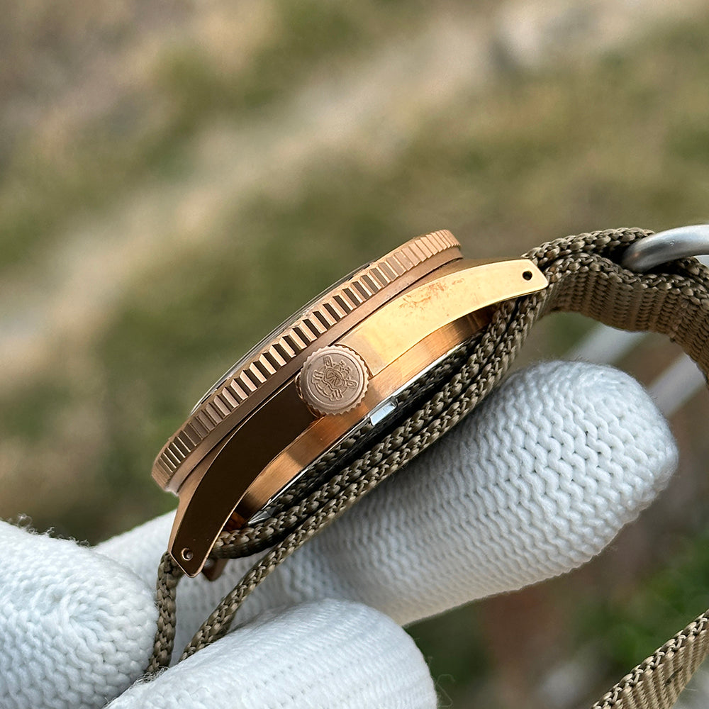 Steeldive SD1962S bronze case profile showing coin-edge bezel and signed bronze crown, side view