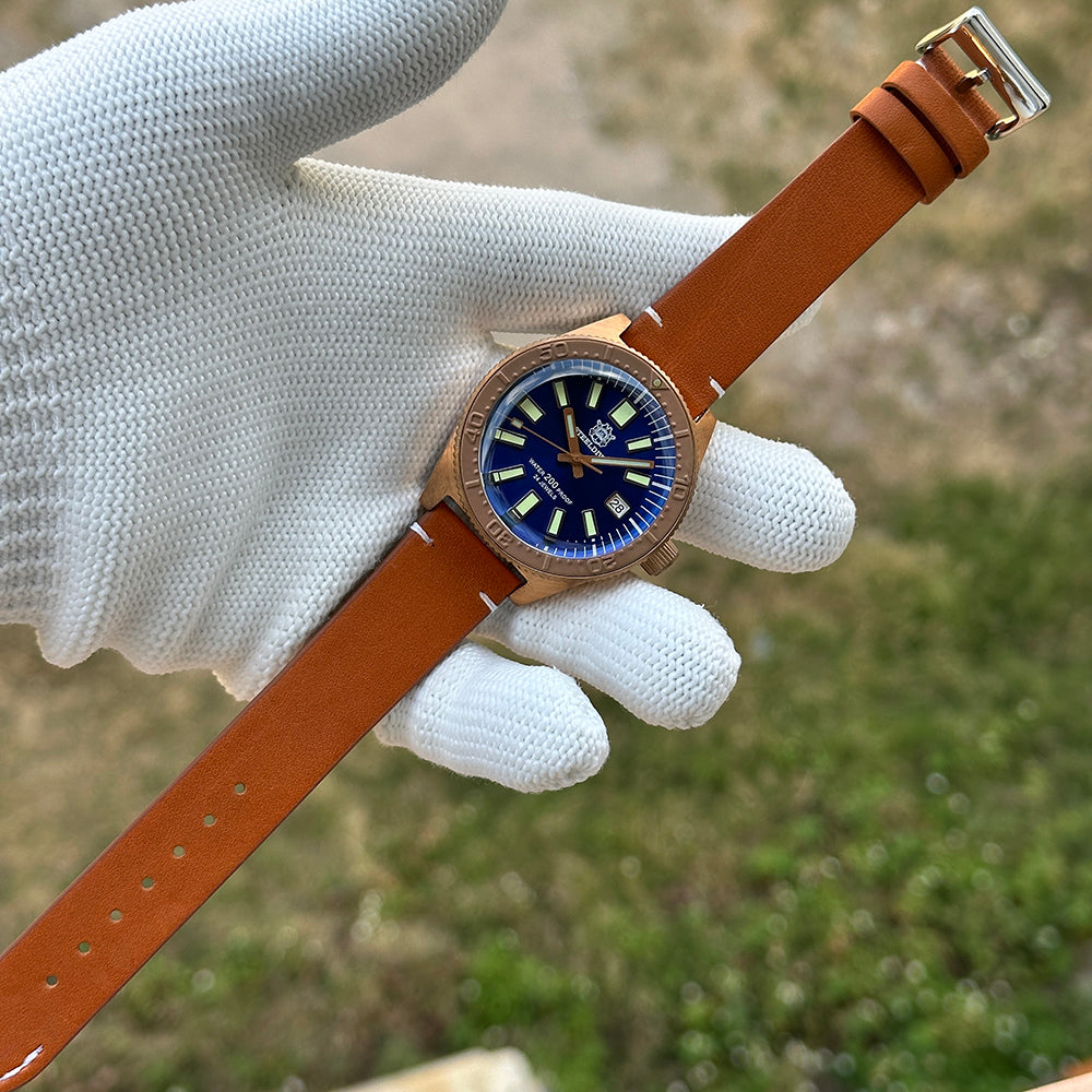 Steeldive SD1962S bronze watch on tan leather dive strap, flat layout with polished buckle