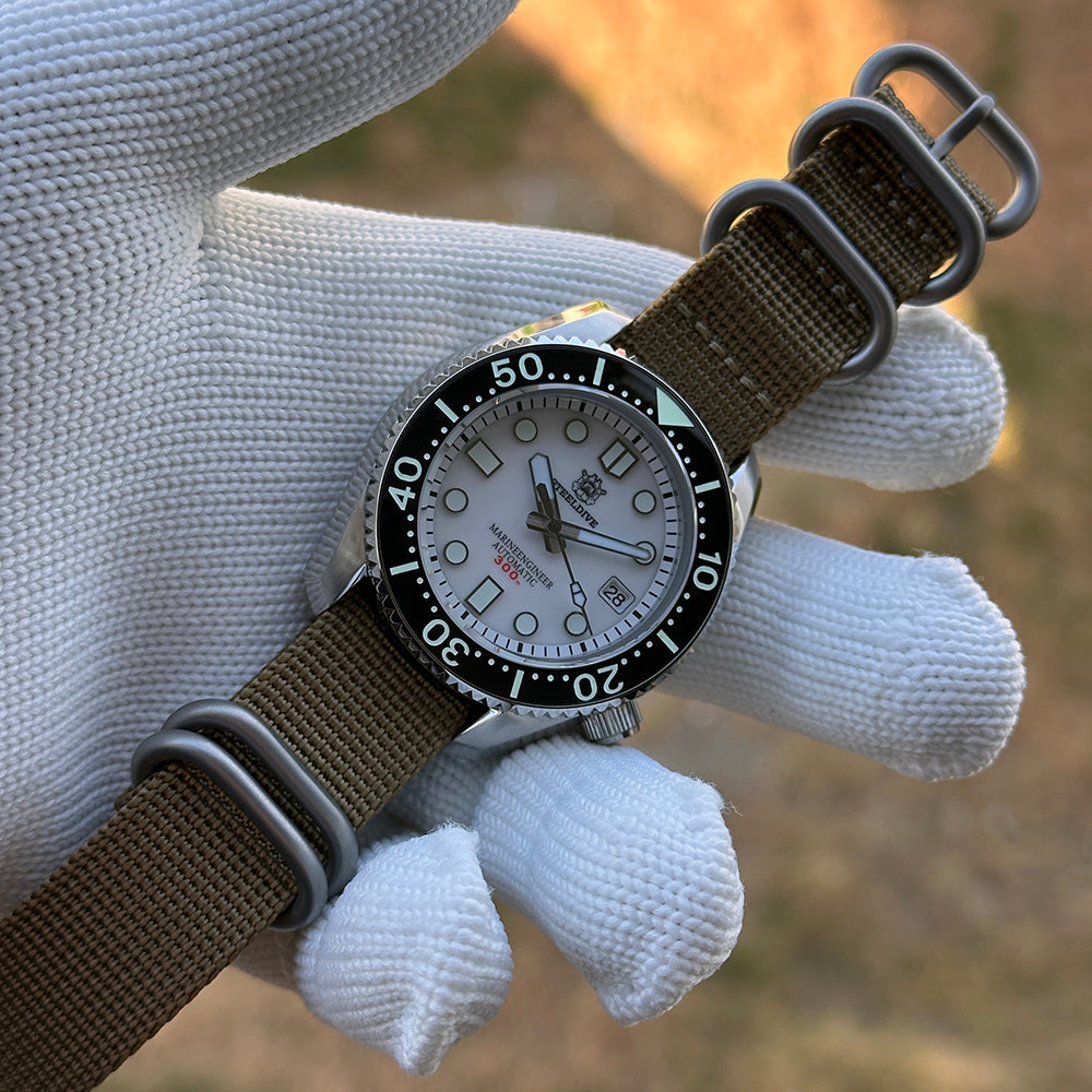 Steeldive SD1968 white dial dive watch on green nylon NATO strap, hand-held outdoor shot