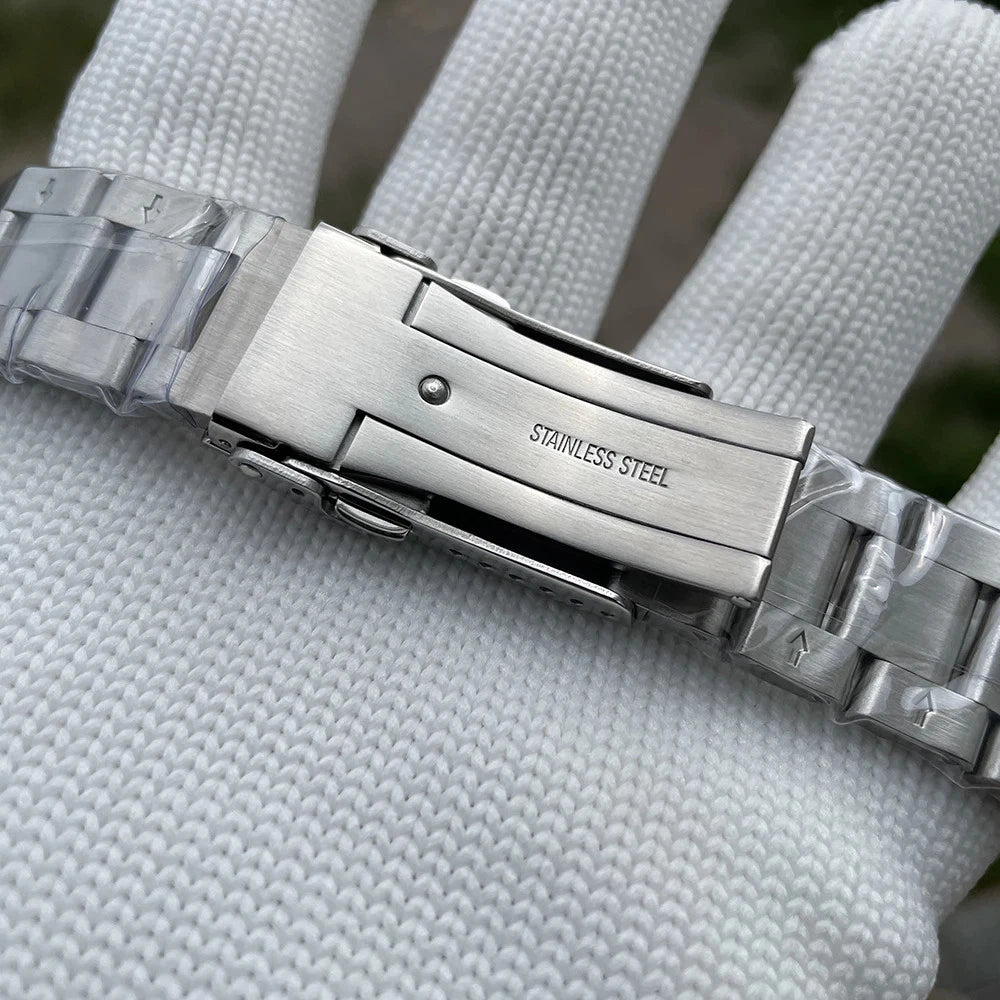 Steeldive SD1970C stainless steel bracelet clasp with 'Stainless Steel' engraving, held by gloved hand.