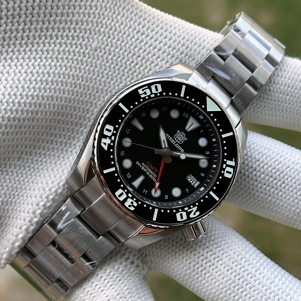 Steeldive SD1971GMT black bezel GMT watch on steel bracelet in gloved hand, wrist scene