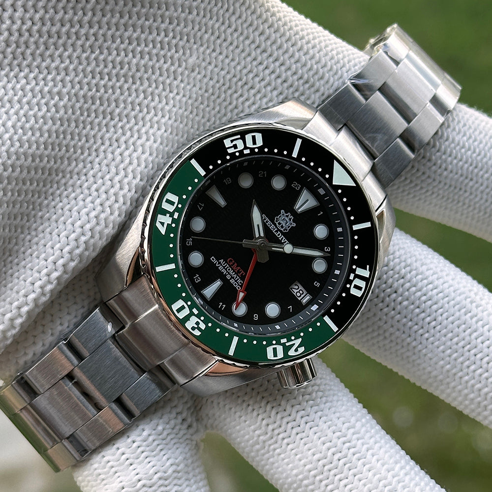 Steeldive SD1971GMT green ceramic bezel GMT watch on steel bracelet in gloved hand, wrist view