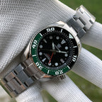 Steeldive SD1971GMT green ceramic bezel GMT watch on steel bracelet in gloved hand, wrist view