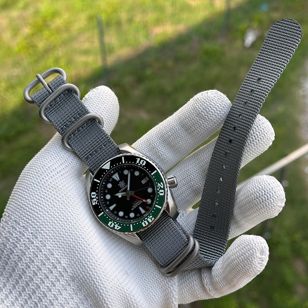 Steeldive SD1971GMT GMT watch with green bezel paired with grey NATO strap, in-hand wrist scene