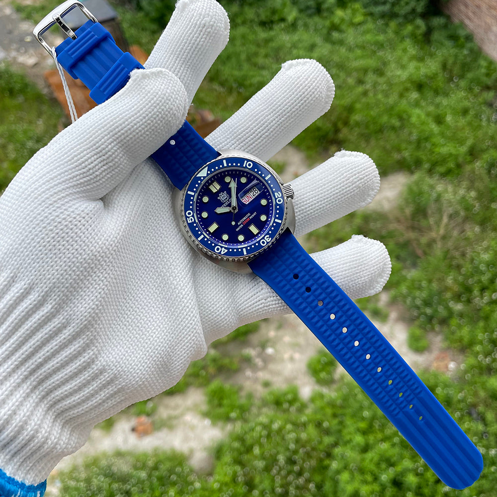 Steeldive SD1972 blue dial turtle diver with blue waffle rubber strap fully extended in gloved hand