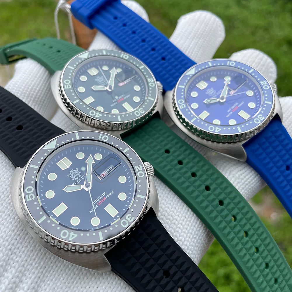 Steeldive SD1972 turtle diver trio flatlay showing black, green and blue variants on rubber straps
