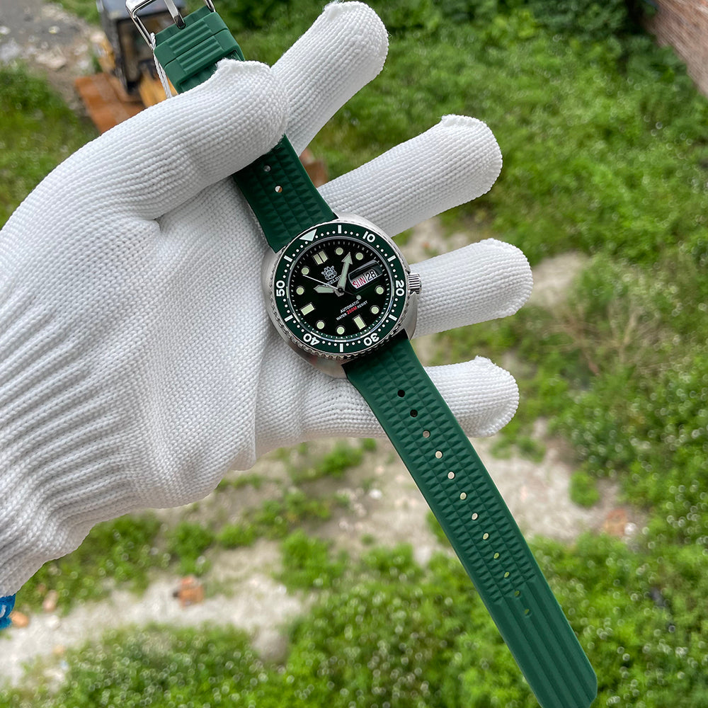 Steeldive SD1972 green dial turtle diver with green waffle rubber strap detail in gloved hand