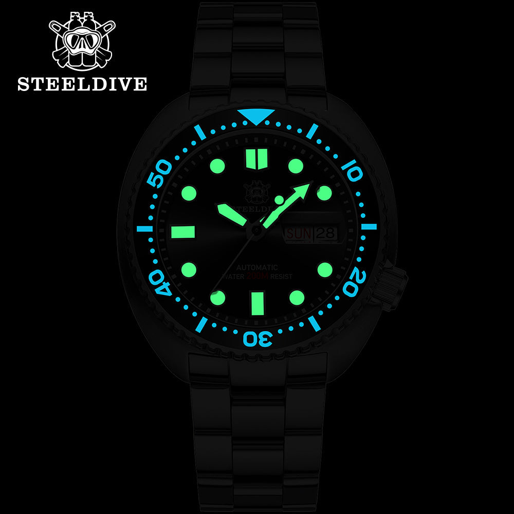 Steeldive SD1972 turtle diver lume shot showing green and blue luminous indices and hands in the dark