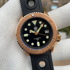 Steeldive SD1973S bronze coin-edge bezel and black dial closeup with green lume pip indices