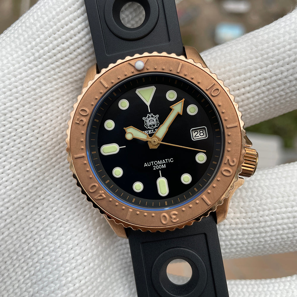 Steeldive SD1973S bronze coin-edge bezel and black dial closeup with green lume pip indices