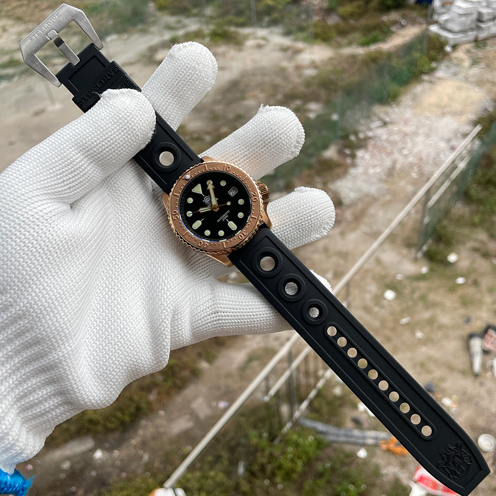 Steeldive SD1973S bronze watch laid out with full black rubber dive strap and signed steel clasp