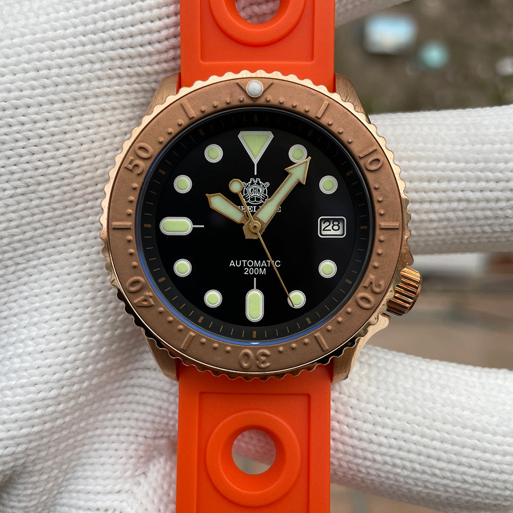 Steeldive SD1973S bronze case watch on orange rubber strap, dial closeup with green lume indices