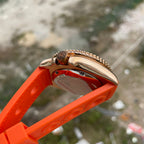 Steeldive SD1973S bronze case side profile with orange rubber strap, polished crown and bezel coin edge