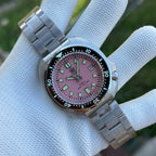 Steeldive SD1974 pink dial macro with steel bracelet, green lume markers and date at 3