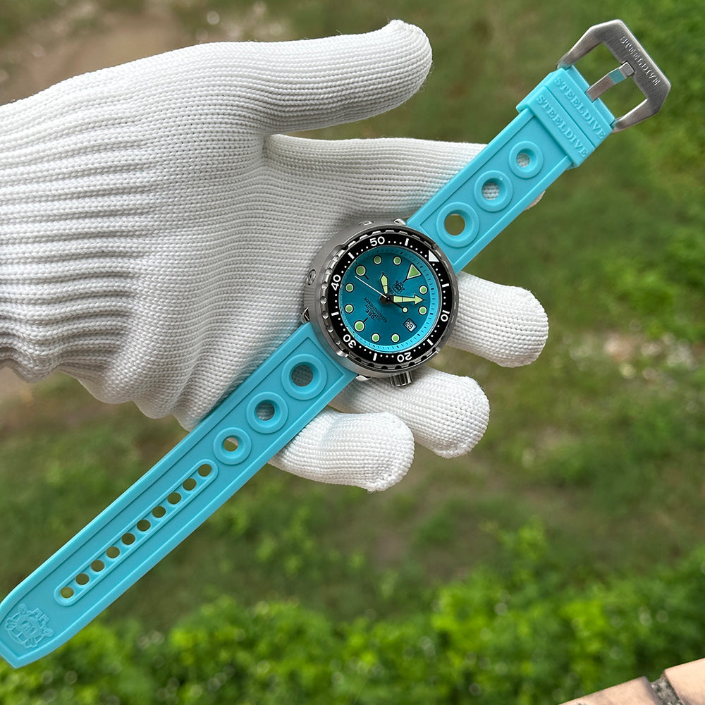 Steeldive SD1975 tuna ice blue dial on matching blue rubber strap in gloved hand outdoor view