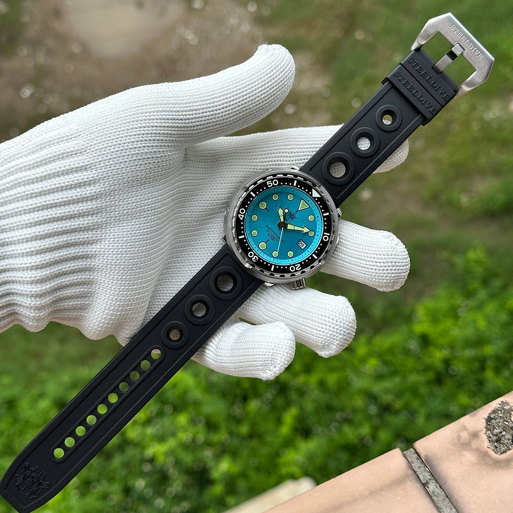 Steeldive SD1975 tuna ice blue dial on black rubber strap held in gloved hand, outdoor lifestyle