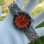 Steeldive SD1975 tuna 47.5mm case with black 60-minute bezel insert and matte orange dial, angle view