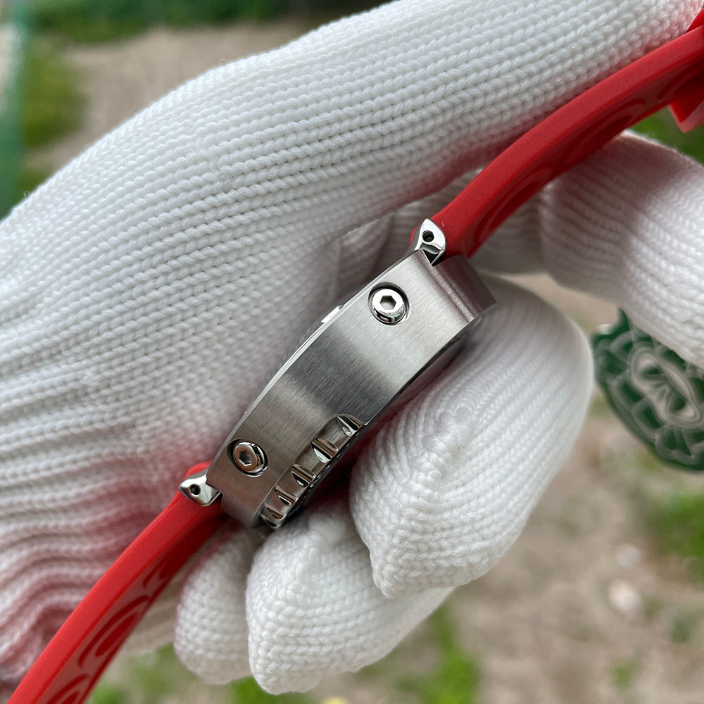 Steeldive SD1975 red rubber strap with brushed steel signed buckle, held in gloved hand