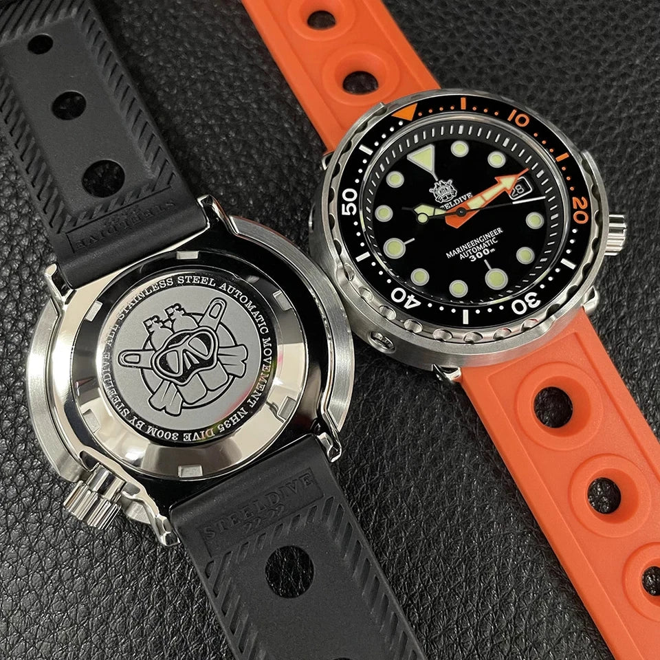 Side-by-side view of two Steeldive SD1975C dive watches on textured surface showing stainless steel caseback with black rubber strap and front view with orange rubber strap, black dial with orange accents and luminous markers, NH35 automatic movement.