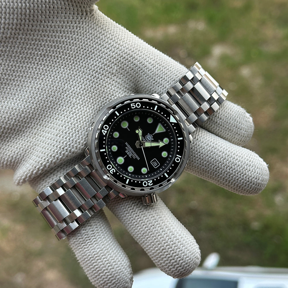 STEELDIVE SD1975K held in a gloved hand on its stainless steel tank bracelet