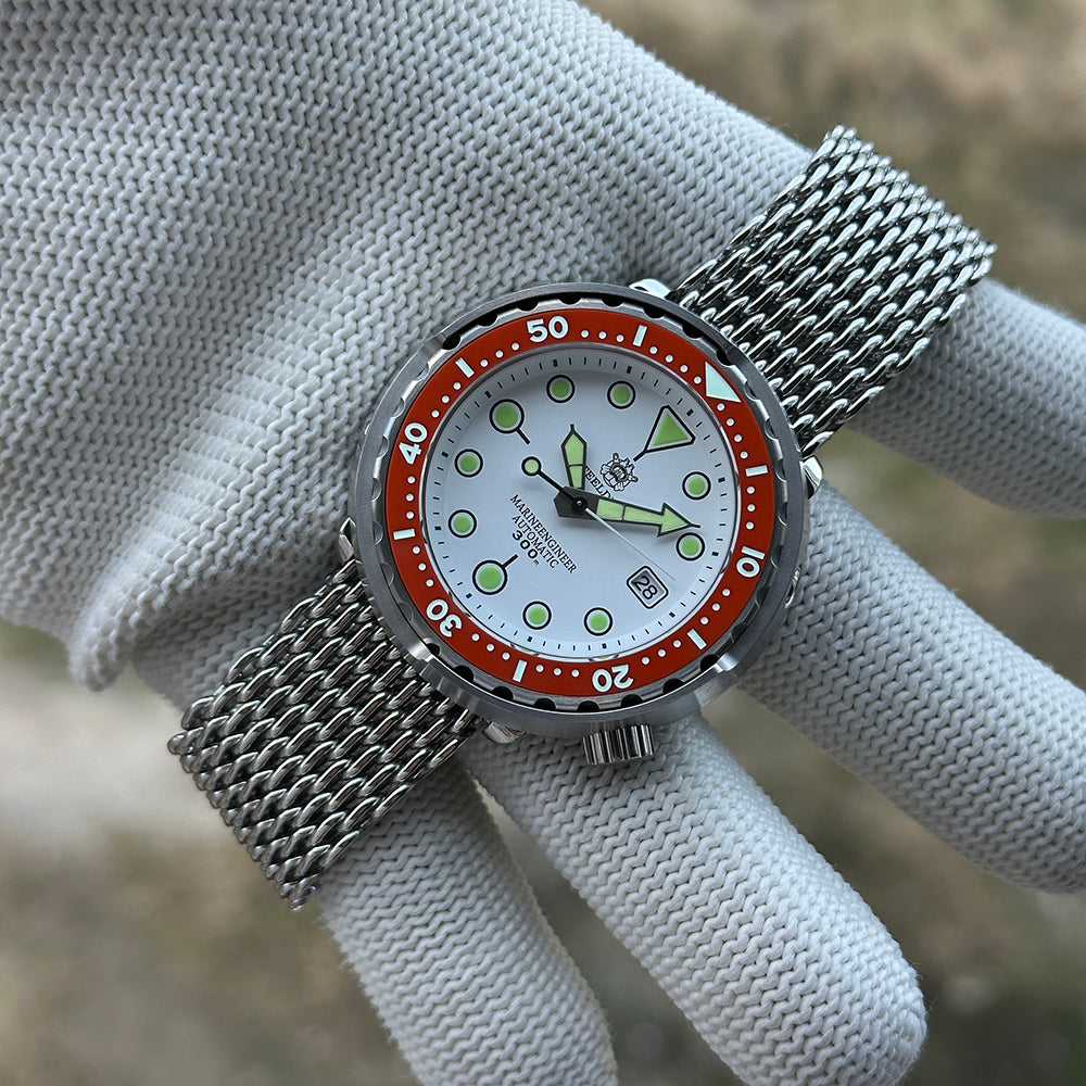 STEELDIVE SD1975N orange bezel on a steel mesh bracelet held in a gloved hand