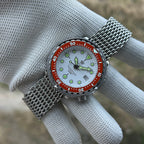 STEELDIVE SD1975N orange bezel on a steel mesh bracelet held in a gloved hand
