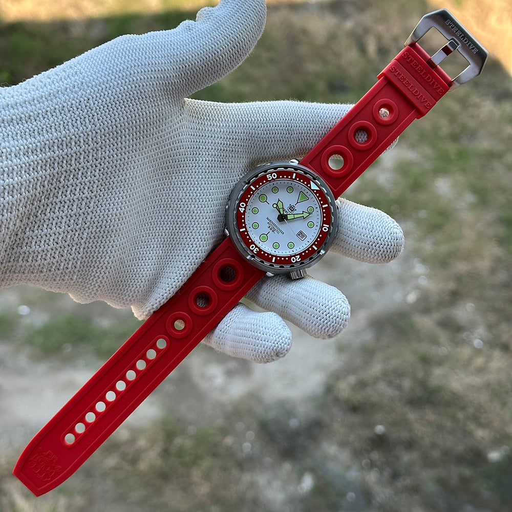 STEELDIVE SD1975N red bezel on a red perforated rubber strap held in a gloved hand