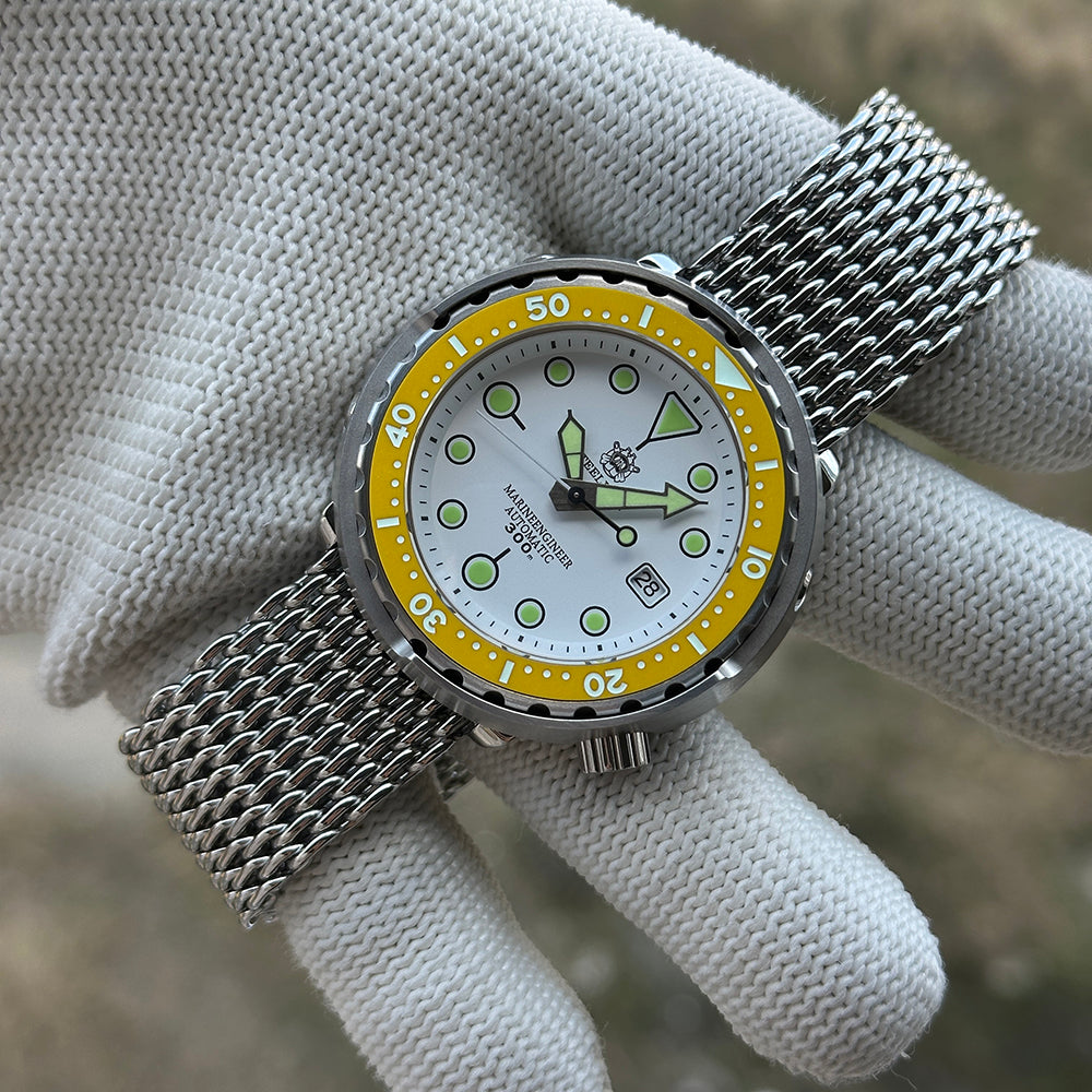 STEELDIVE SD1975N yellow bezel on a steel mesh bracelet held in a gloved hand