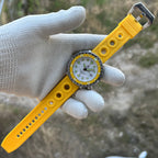 STEELDIVE SD1975N yellow bezel on a yellow perforated rubber strap held in a gloved hand