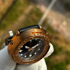 Steeldive SD1975S V1 bronze tuna 300m dive watch angled view with black dial in golden hour light