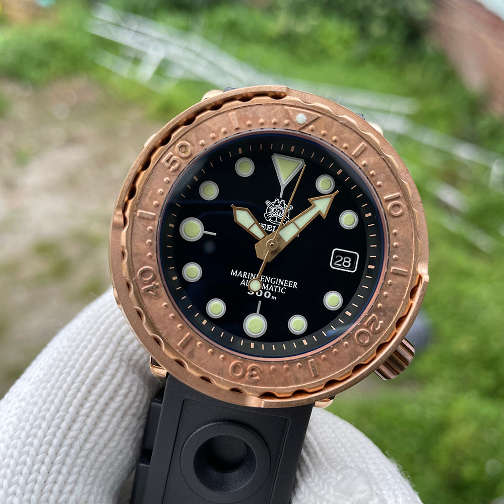 Steeldive SD1975S V2 bronze 300m dive watch dial macro showing applied indices and gold arrow hands