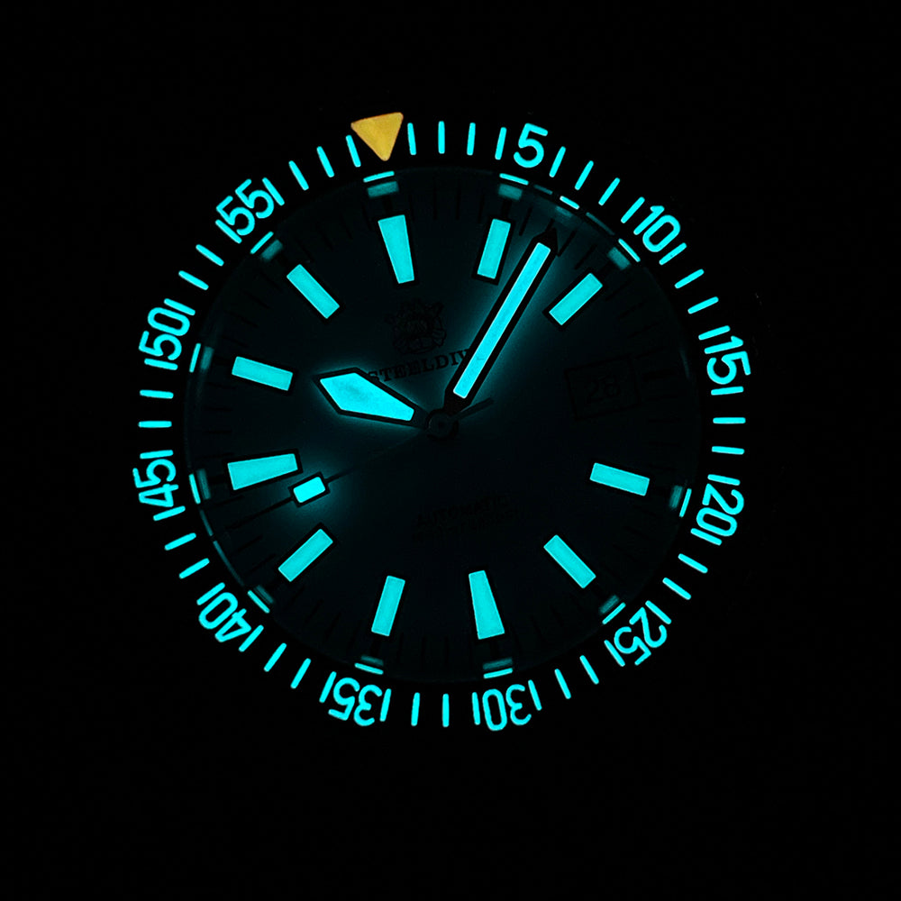 Steeldive SD1983 ceramic dive watch glowing aqua lume on hour markers and bezel pip in the dark