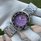 Steeldive SD1983 purple dial dive watch on oyster bracelet styled on white cloth lifestyle shot