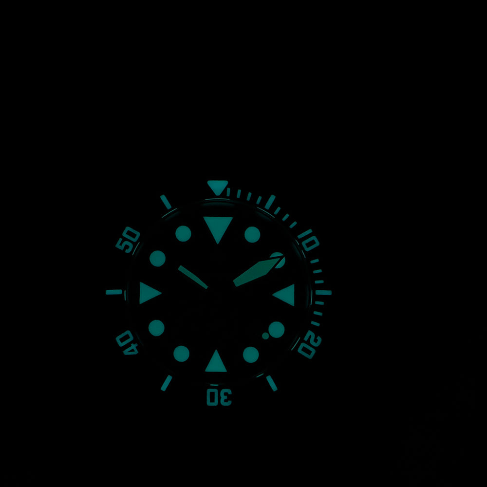 Steeldive SD1987 diver BGW9 lume shot glowing blue-green in darkness on black dial