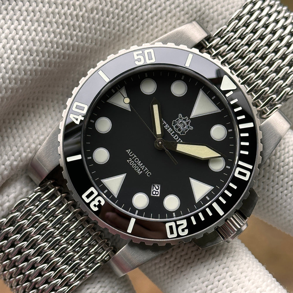 Steeldive SD1987 dive watch black dial close-up with applied indices and mesh bracelet