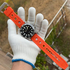 Steeldive SD1987 dive watch on orange rubber strap held in gloved hand outdoors